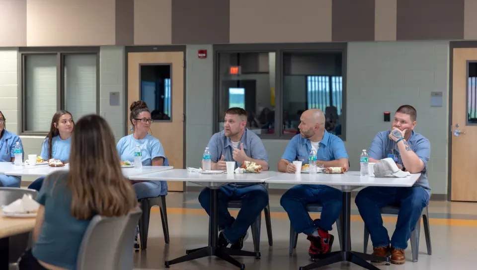 Residents of the Maine Correctional Center answer questions from UNE students. 